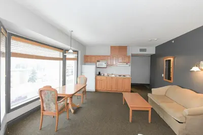 a kitchen and living room with a table and a couch at Prime Hotel in Fort McMurray