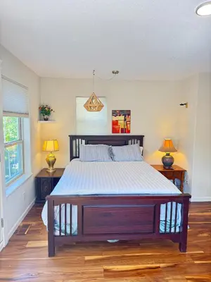 a bedroom with a large bed with two night stands at luxury ocean dock pool villa in Ladysmith