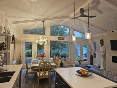 a kitchen and dining room with a table and chairs at luxury ocean dock pool villa in Ladysmith