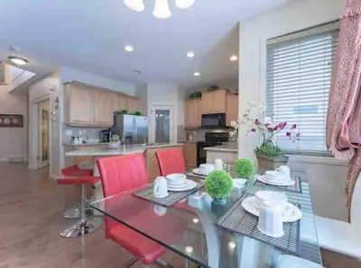 a dining room and kitchen with a glass table and red chairs at 2500 sq house in Springbank Hill BL 261818 in Calgary