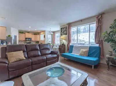 a living room with a couch and a table at 2500 sq house in Springbank Hill BL 261818 in Calgary