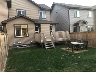 a yard with a table and chairs in front of a house at Cozy and beautiful 3 bedroom house close to lake in Edmonton