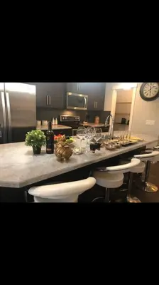 a kitchen with a counter with bar stools and a sink at Cozy and beautiful 3 bedroom house close to lake in Edmonton