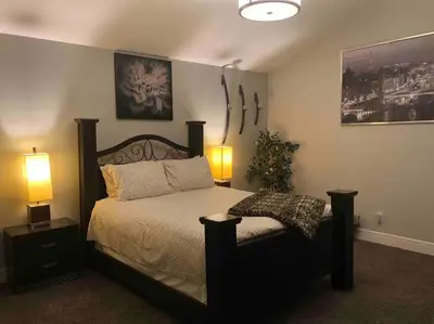 a bedroom with a large bed with two lamps on it at Cheerful and beautiful 3 bedroom home close lake in Edmonton