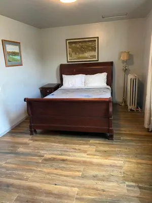 a bed in a bedroom with a wooden floor at Coldwater Hotel in Merritt