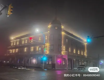 a building with a clock tower on a street at night at Coldwater Hotel in Merritt