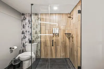 a bathroom with a toilet and a glass shower at Everwild Canmore Hotel in Canmore