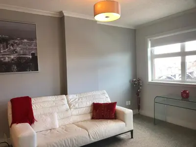 a living room with a white couch and a window at Amicable, Cozy, High Speed Internet, Sleeps 2 Riverview Downtown Apartment in Calgary