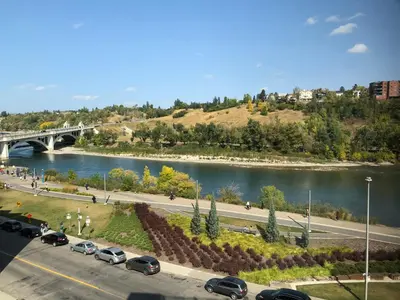 a bridge over a river with cars parked on a street at Amicable, Cozy, High Speed Internet, Sleeps 2 Riverview Downtown Apartment in Calgary