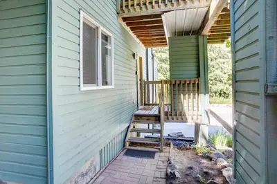 a porch of a house with a wooden chair at Gondola Haus - Free parking in Whistler