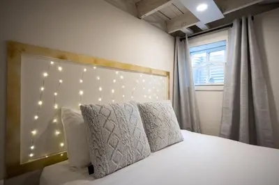 a bedroom with a bed with lights on the wall at Trendy Kensington 3 min Walk Backyard AC Garage in Calgary