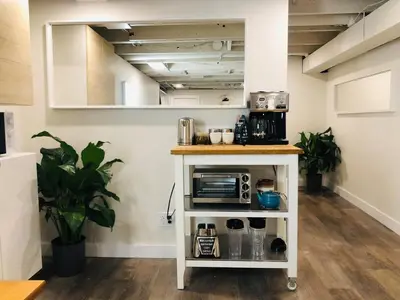 a kitchen with a white cart with a microwave at Trendy Kensington 3 min Walk Backyard AC Garage in Calgary