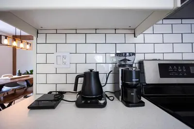 a kitchen counter with a coffee maker and a coffeemaker at Trendy Kensington 3 min Walk Backyard AC Garage in Calgary