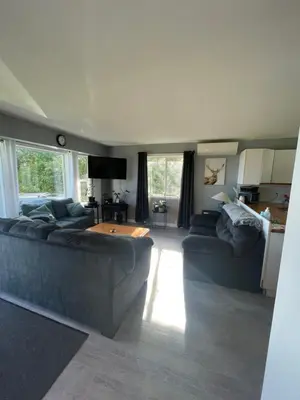 a living room with a couch and a table at Sunrise Mountain view Skidegate House in Skidegate