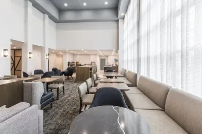 a waiting room with couches and tables and windows at Staybridge Suites - Dawson Creek by IHG in Dawson Creek