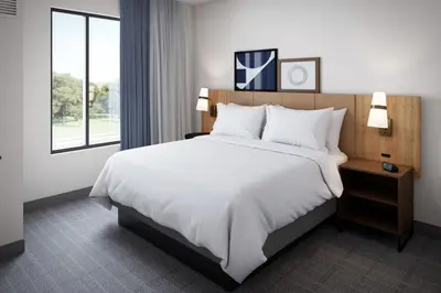 a hotel room with a large bed and a window at Staybridge Suites - Dawson Creek by IHG in Dawson Creek