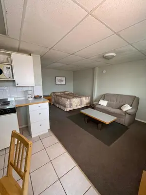 a living room with a couch and a bed at Raccoon Lodge Motel in Sylvan Lake