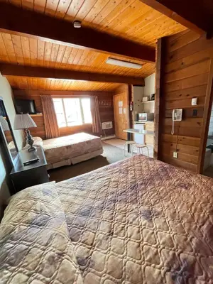 a bedroom with a large bed in a room at Raccoon Lodge Motel in Sylvan Lake