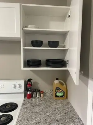 a kitchen with a stove and plates on shelves at Wonderful 2-bedroom apartment in Camrose