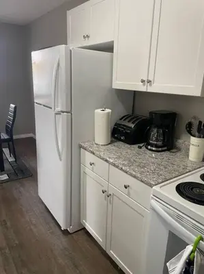 a kitchen with white cabinets and a white refrigerator at Wonderful 2-bedroom apartment in Camrose
