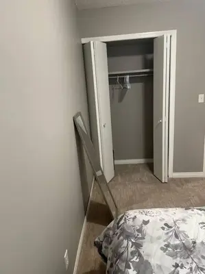 a bedroom with a bed and a closet with a door at Wonderful 2-bedroom apartment in Camrose