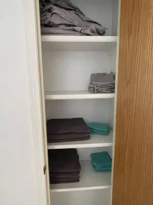 a closet filled with towels and folded clothes at Cozy Home in Camrose