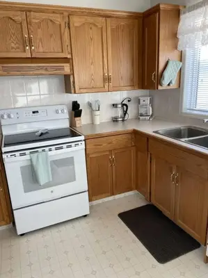 a kitchen with a white stove and a sink at Cozy Home in Camrose