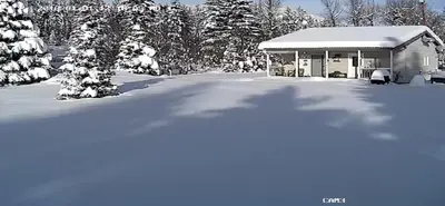 a building covered in snow with trees in the background at Witt's End Ranch Private Get Away in Princeton