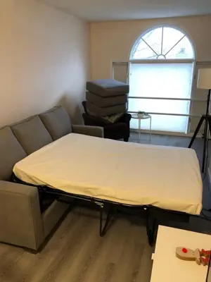 a bed in a room with a couch and a window at unit #301 Mountain view 2BR in Canmore Down town in Canmore