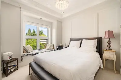 a white bedroom with a large bed and a window at Vancouver Shangrila House in Richmond