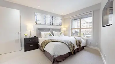 a bedroom with a large bed and a window at 260 The Aspens - Ski In Ski Out in Whistler