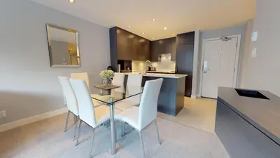 a kitchen with a glass table and white chairs at 260 The Aspens - Ski In Ski Out in Whistler