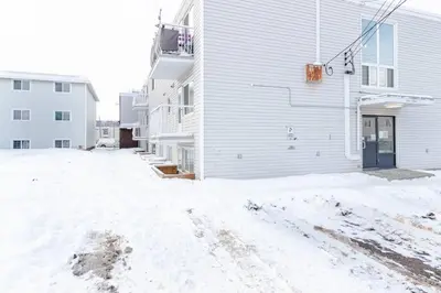 a snow covered yard next to a building at Modern & Stylish 1-Bedroom Unit in Edmonton