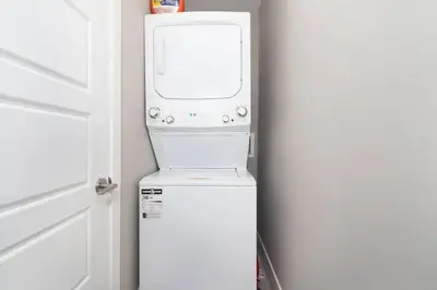 a washer and dryer in a room with a door at Modern & Stylish 2-Bedroom Unit in Edmonton