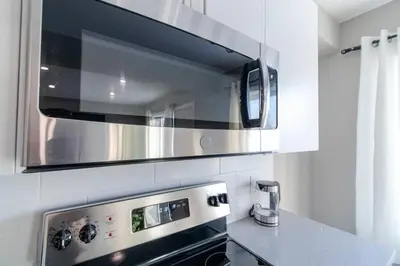a kitchen with a stove and a microwave at Modern & Stylish 2-Bedroom Unit in Edmonton