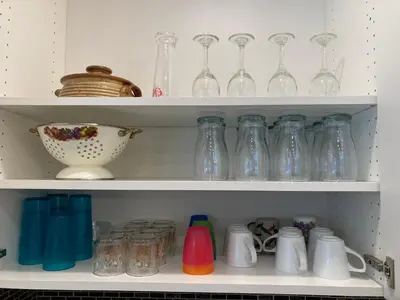 a shelf filled with glass vases and a bowl at Bright poolside walkout two bedroom basement suite in the Okanagan in Penticton