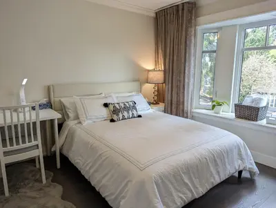 a white bedroom with a bed and a window at Nice home away at Vancouver near YVR in Vancouver