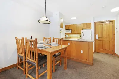 a kitchen with a wooden table and wooden chairs at Perfect Ski or Bike in-out Hot Tub Pool in Panorama