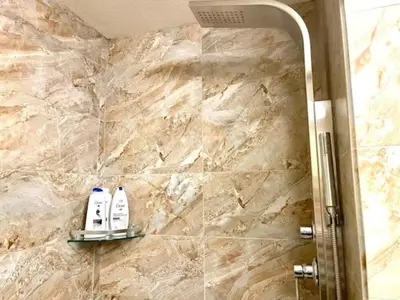 a bathroom with two shampoo bottles on a stone wall at Falcon Crest Lodge 1 BR Condo With Gym & Hot-Tubs & Mountain View in Canmore