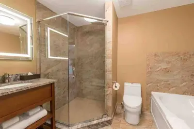 a bathroom with a shower and a toilet and a sink at Falcon Crest Lodge 1 BR Condo With Gym & Hot-Tubs & Mountain View in Canmore