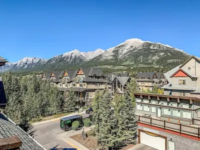 a resort town with a mountain in the background at Mountain Retreat - Modern and Bright with Panorama Views 2 bedrooms, 4 beds, heated all-year outdoor pool, hottub, balcony, Banff Park Pass in Canmore