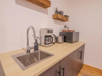a kitchen counter with a sink and a microwave at Winter's Hideaway Suite in Ucluelet