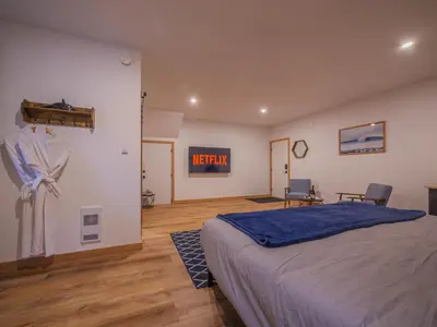 a bedroom with a bed and a sign on the wall at Winter's Hideaway Suite in Ucluelet