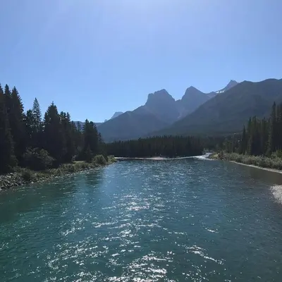 a view of a river with mountains in the background at Wanna get away next Summer and Fall at the Crossing in Canmore