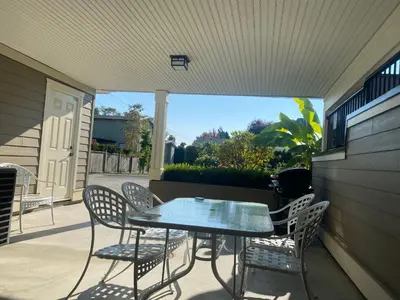 a patio with a table and chairs on a porch at New two-bedroom legal suite with parking in White Rock