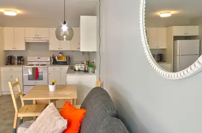 a living room with a couch and a table and a mirror at Zen Retreat Langford in Victoria