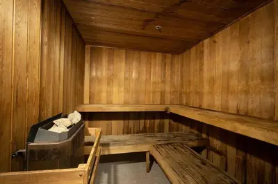 a sauna with a bench and a chair in it at Heart of Downtown King Suite/Parkng/Pool/Gym/Sauna in Vancouver