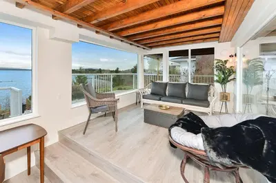 a living room with a couch and some windows at The Beach House Suite by EMR Vacation Rentals in Chemainus