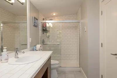 a bathroom with a toilet and a sink and a shower at Pacific Forest Beach House in Parksville