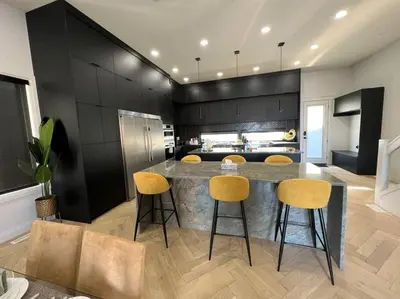 a kitchen with a large counter with yellow bar stools at Stunning 3BR Luxury Home N/Edm*2 king beds* in Edmonton